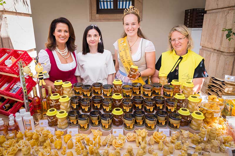 Vier Frauen vor einem Berg von Honigprodukten
