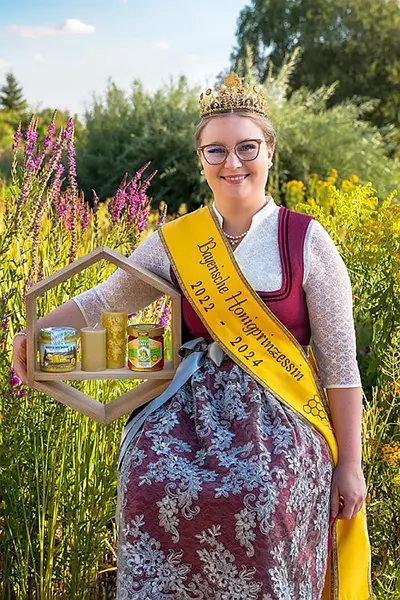 Die Honigprinzessin Linda mit einer Holzwabe mit Bienenprodukten
