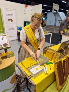 Die Bayerische Honigprinzessin Linda beim Zuschneiden der frisch gepressten Mittelwand.